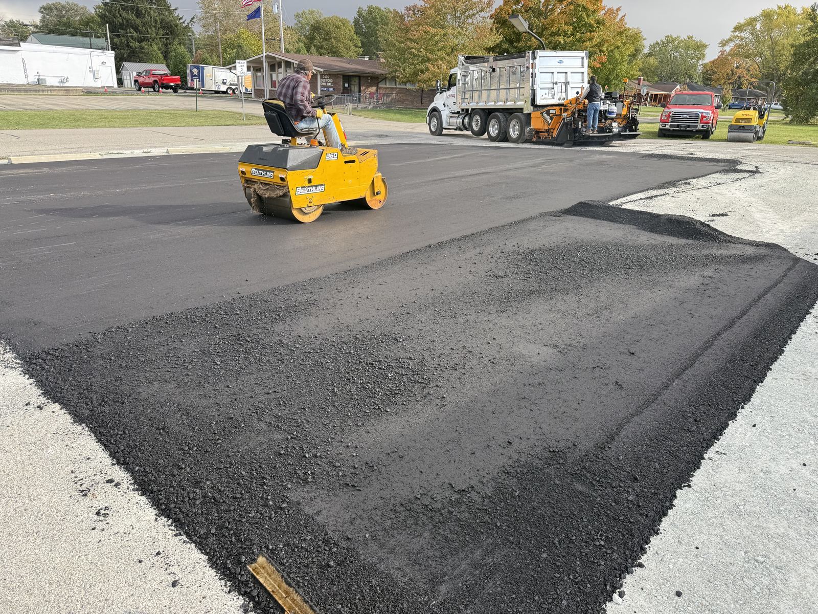 Commercial parking lot paving crew with paver and roller