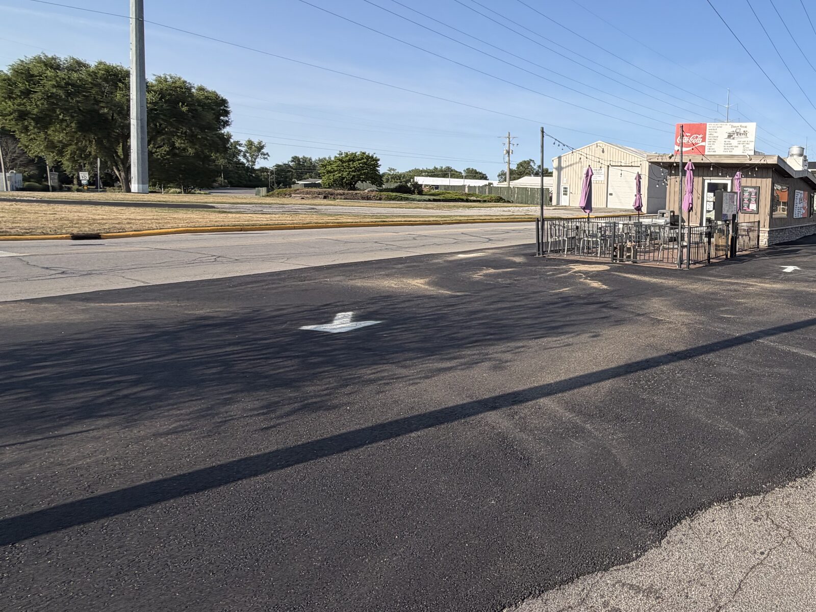 Freshly paved commercial parking lot with new asphalt overlay at a storefront