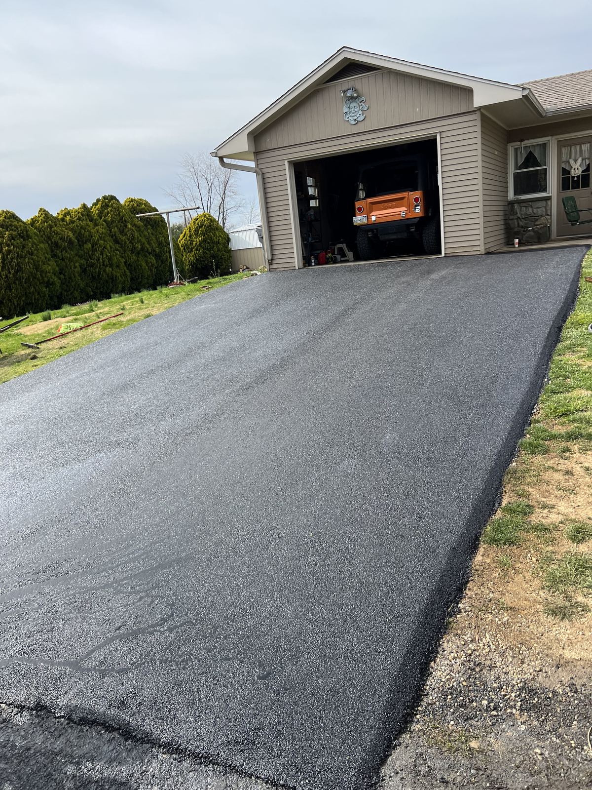 Sloped asphalt driveway installation with smooth finish